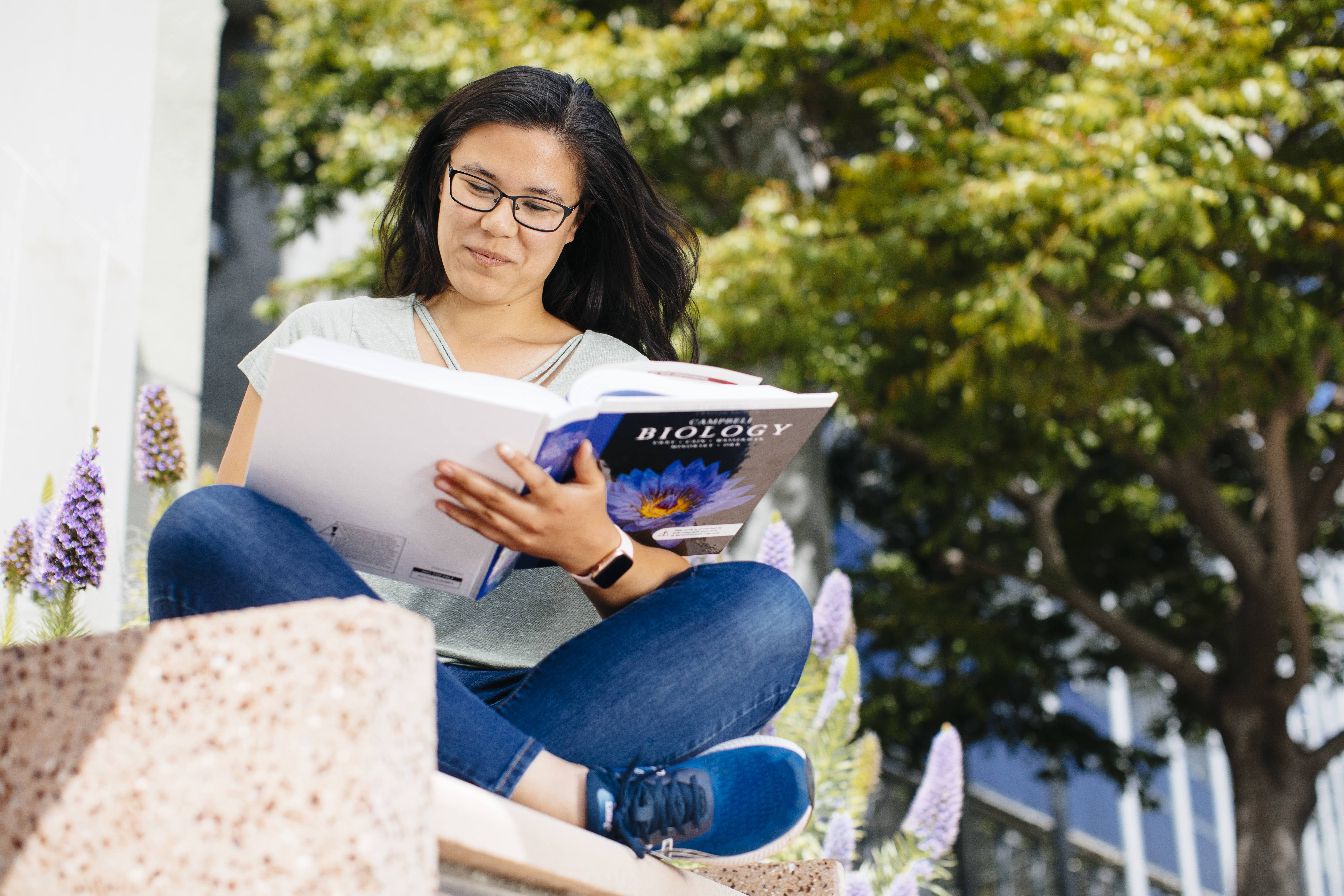 This is a photo of a student reading their biology textbook.